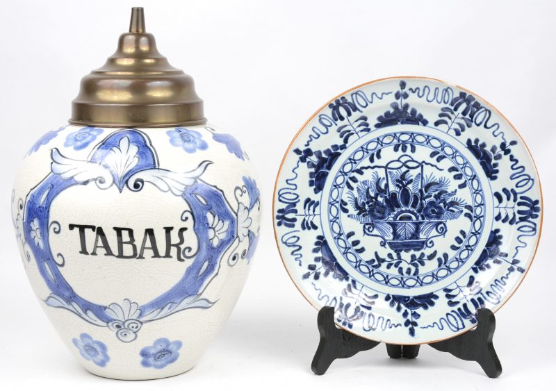 Een tabakspot en een Delftse sierschotel van blauw en wit aardewerk (Ø 24 cm).