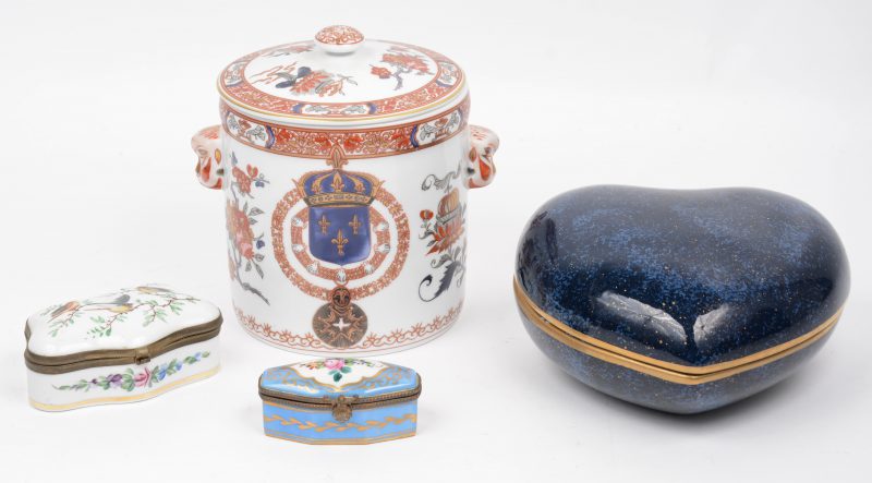 Een lot van vier verschillende porseleinen dekseldoosjes, waarbij een hartvormig met blauw glazuur van Christian Dior, één van Limoges en één Japans en een Portugees met Japans decor.