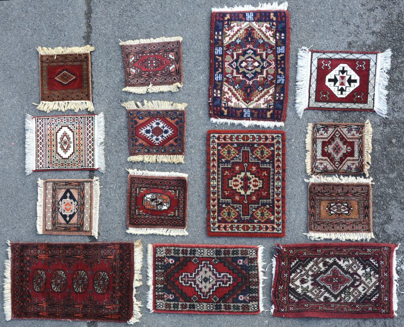 Een lot van dertien kleine wollen tapijtjes.