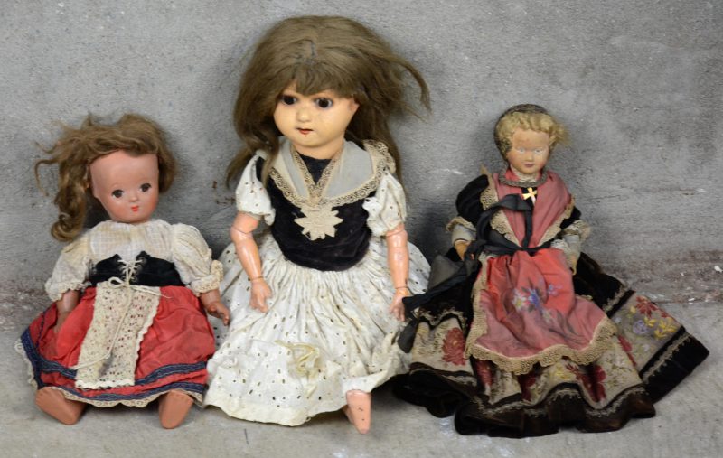 Drie diverse antieke poppen met klederdrachten. Zonder of met onleesbare merken. Letsels en slijtage.