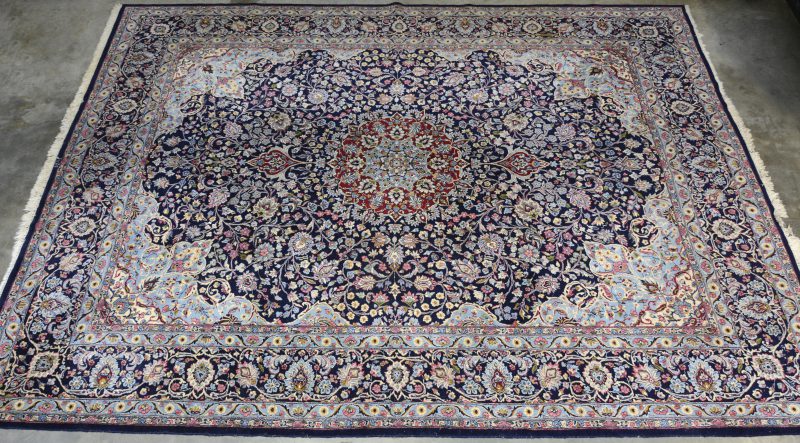 Een handgeknoopt Perzisch wollen tapijt met bloemendecor.
