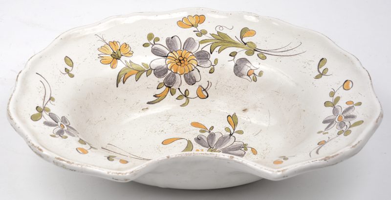 Een aardewerken scheerbekken met meerkleurig bloemenmotief. XIXe eeuw.