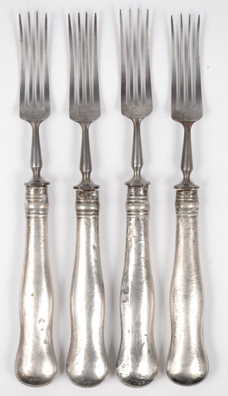 Vier antieke vorken met zilveren heften.