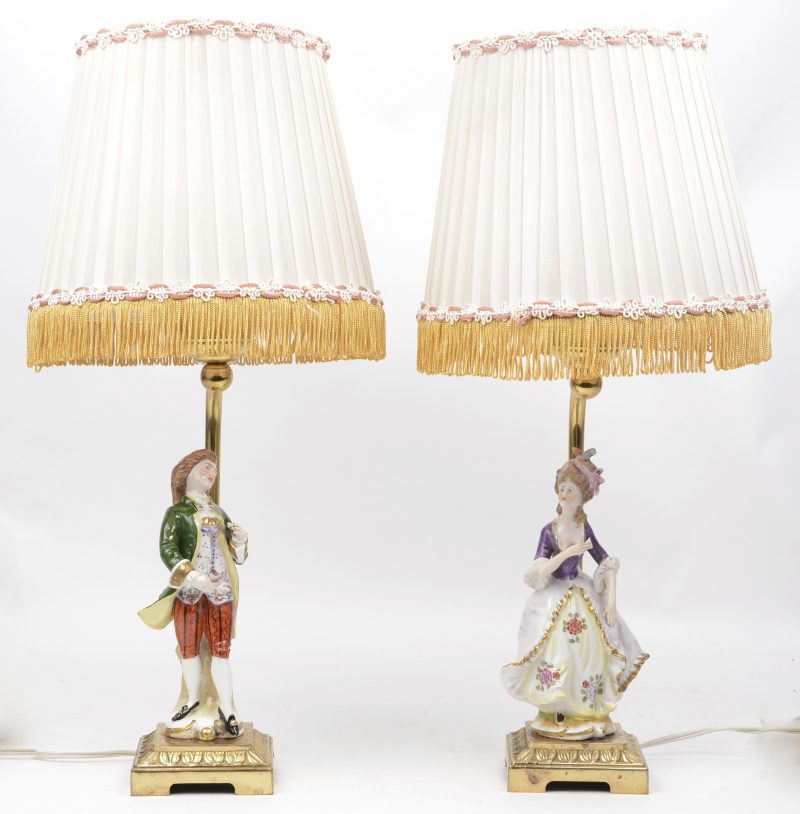 Een paar lampvoetjes van meerkleurig Saksisch (?) porselein in de vorm van een edele dame en heer. Op messingen voetstuk.