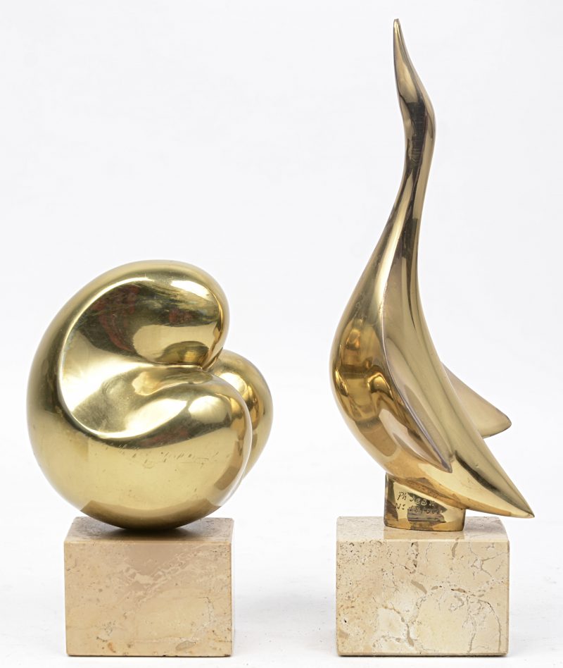 Twee verschillende gestileerde vogels van verguld brons op beige marmeren sokkels.