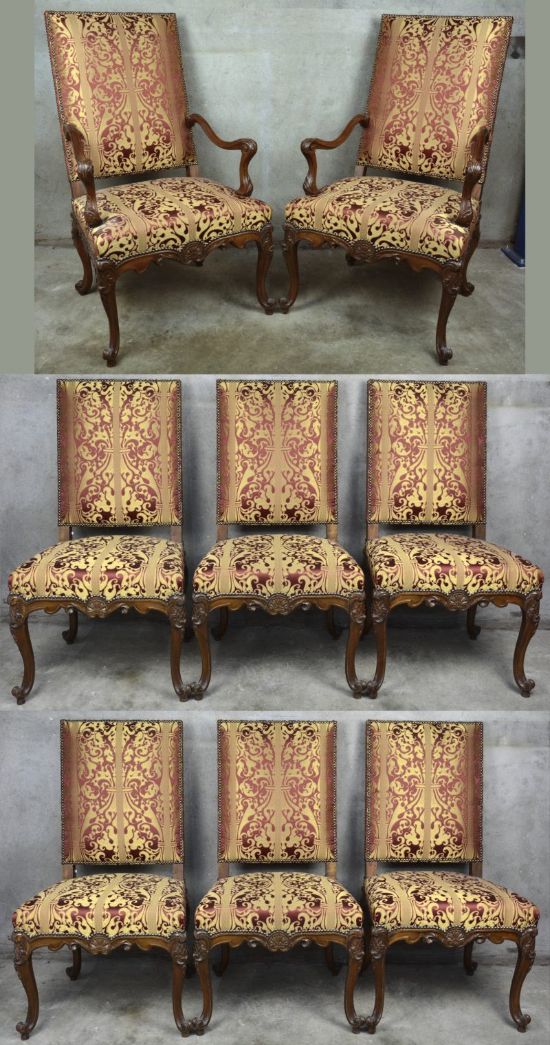 Een reeks van acht gesculpteerde stoelen en twee armstoelen in barokke stijl met gouden en bordeauxrode bekleding.