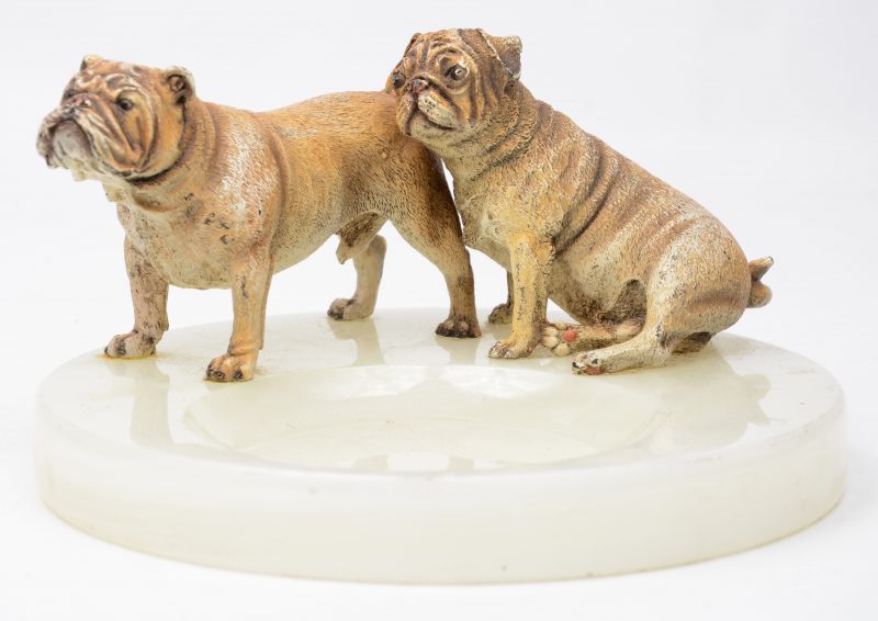 Een onyxen asbak met twee gepolychromeerd bronzen bulldogs.