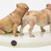 Een onyxen asbak met twee gepolychromeerd bronzen bulldogs.