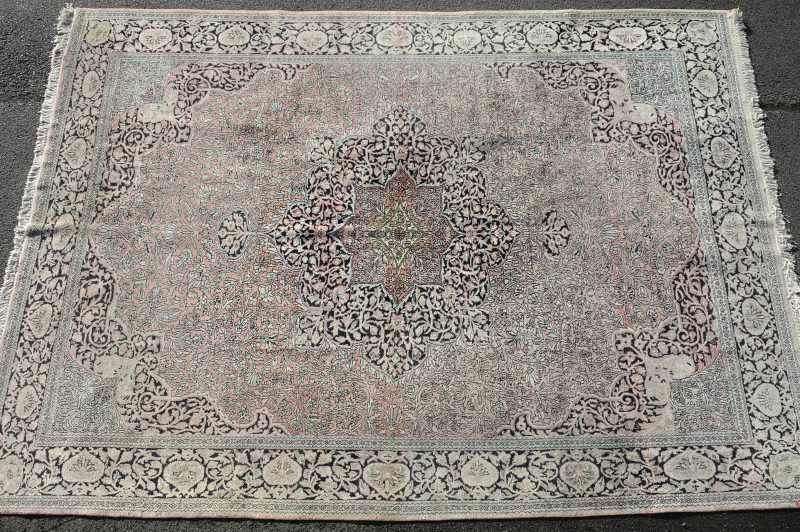 Een handgeknoopt Perzisch wollen tapijt. Verkleuring.