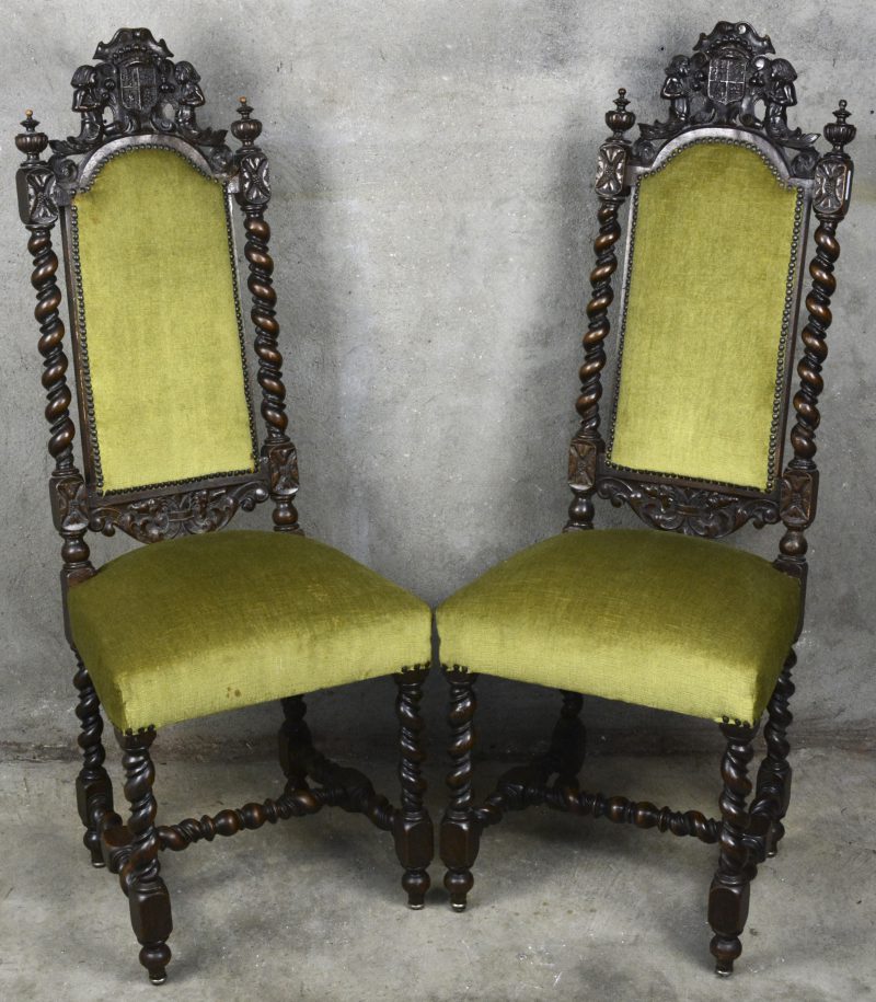 Een paar gebeeldhouwd houten stoelen in barokke stijl, versierd met meerminnen bij een wapenschild en met getorste spijlen en poten. Bekleed met groen fluweel. Eén beschadigd.