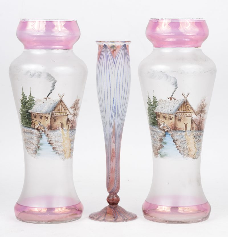 Een paar gegivreerde glazen vazen met handgeschilderd landschapdecor. Lichte slijtage aan de rand (H. 27,5 cm), evenals een lelievormig glazen soliflorvaasje (H. 24,5 cm).