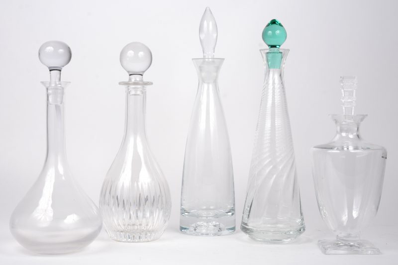 Een lot van vijf verschillende kleurloze karaffen, waarbij drie kristallen en twee glazen. Eén gemerkt van Lalique, een andere van Da Vinci.