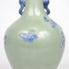 Een vaas van Chinees porselein met een decor van vogels en bloemen in blauw op celadonkleurige fond. Schade aan de rand.