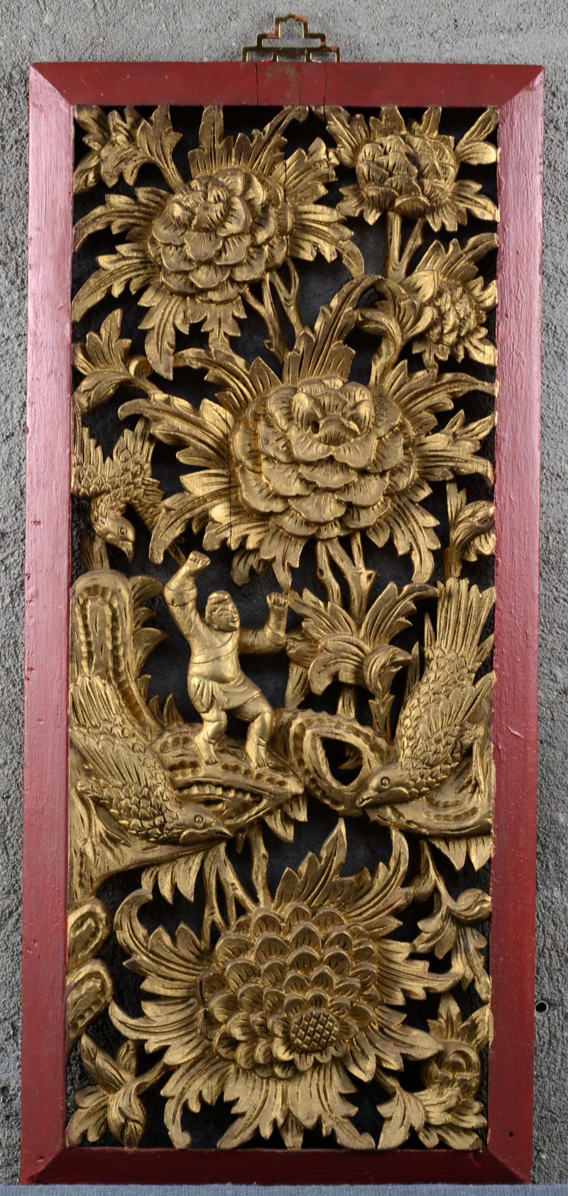 Een opengewerkt en gesculpteerd Chinees wandreliëf van rood en verguld hout met personages, bloemen en vogels.
