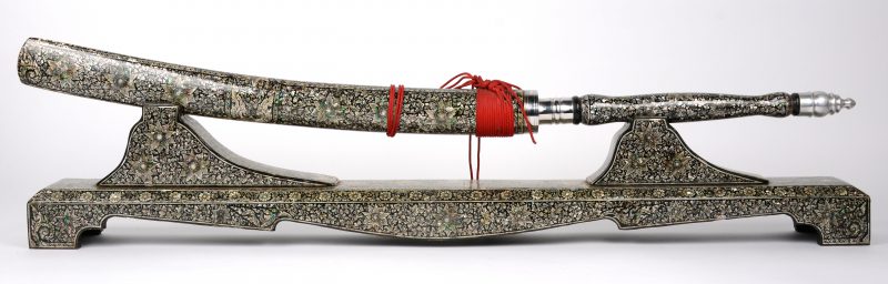 Een Indisch wapen in schede en met houder, versierd met parelmoer. Karnataka.