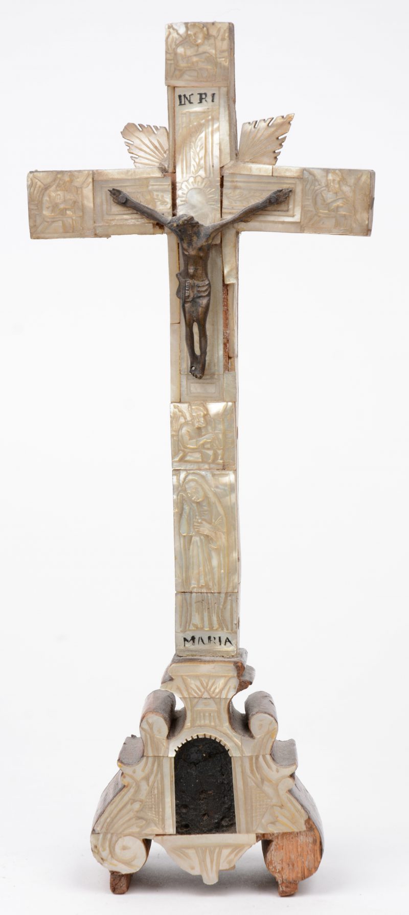 Een antiek kruisbeeldje, versierd met parelmoeren plaatjes met gegraveerde decors en verschijdene reliekhoudertjes aan de achterkant. XIXe eeuw.