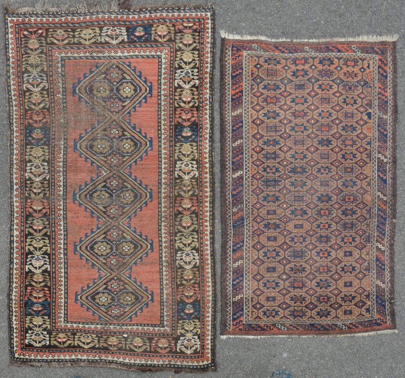 Twee handgeknoopte Turkse wollen tapijtjes. Eén met slijtage.