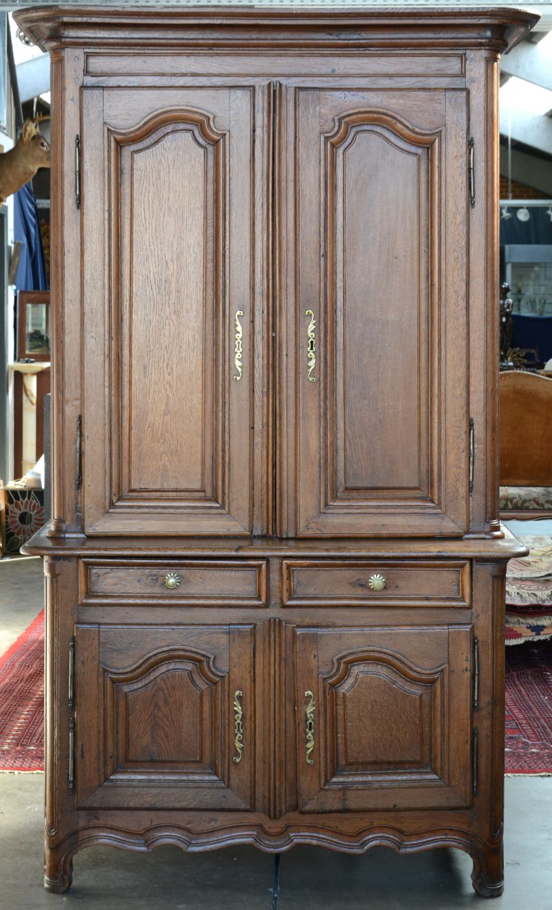 Een tweeledig eikenhouten meubel in Naamse stijl met twee keer twee gemoulureerde paneeldeuren.