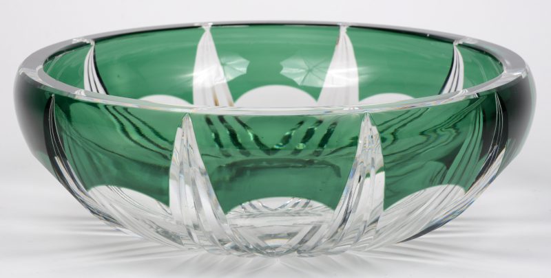 Een ronde coupe van geslepen kristal, in de massa deels groen gekleurd. Onderaan gemerkt.