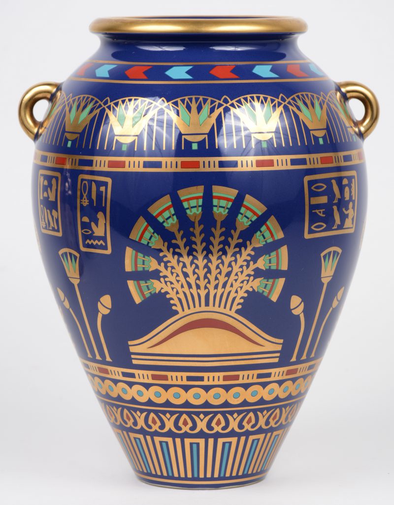 “The Golden vase of Bast”. Een porseleinen vaas met meerkleurig en verguld decor op blauwe fond in antiek egyptisch stijl. Gedateerd 1987.
