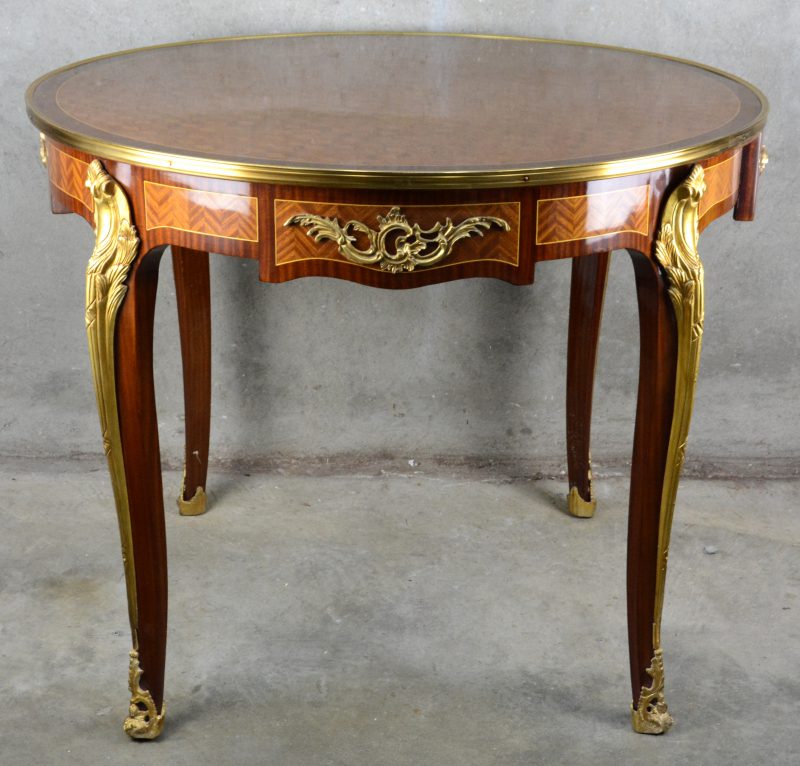 Een ronde tafel in Lodewijk XV stijl met een lade.