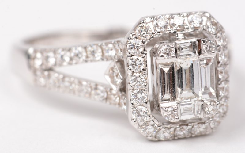 Een 18 K witgouden ring bezet met briljanten en diamant baguetten met een gezamenlijk gewicht van +- 1 ct.