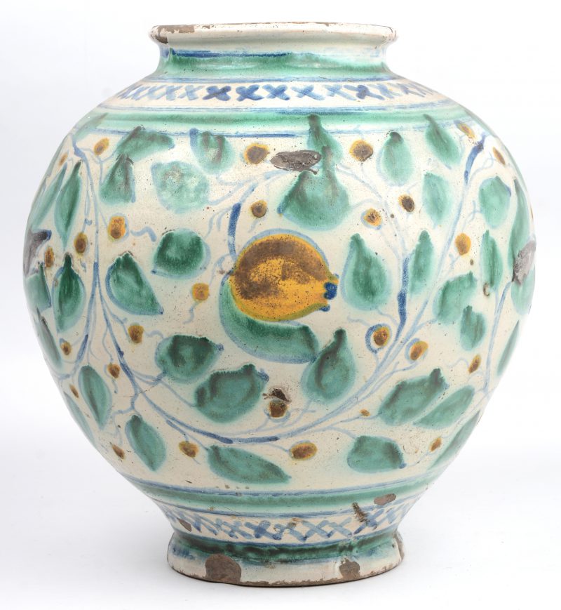 Een aardewerken vaas in de stijl van Iznik met een polychroom decor van bladeren en bloemen. Randslijtage.