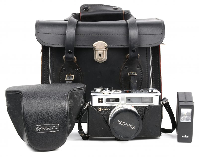 Een oude fotocamera met toebehoren in lederen tas.