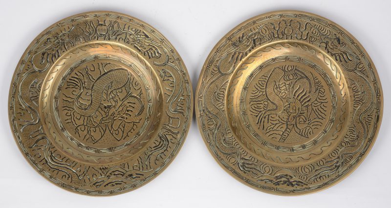 Een paar Aziatishce bronzen sierbordjes met gergraveerde drakendecors.