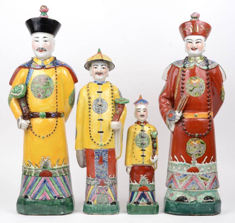 Vier staande personages van meerkleurig Chinees porselein, waarbij drie met ruyi. De kleinste beschadigd aan de hoed.