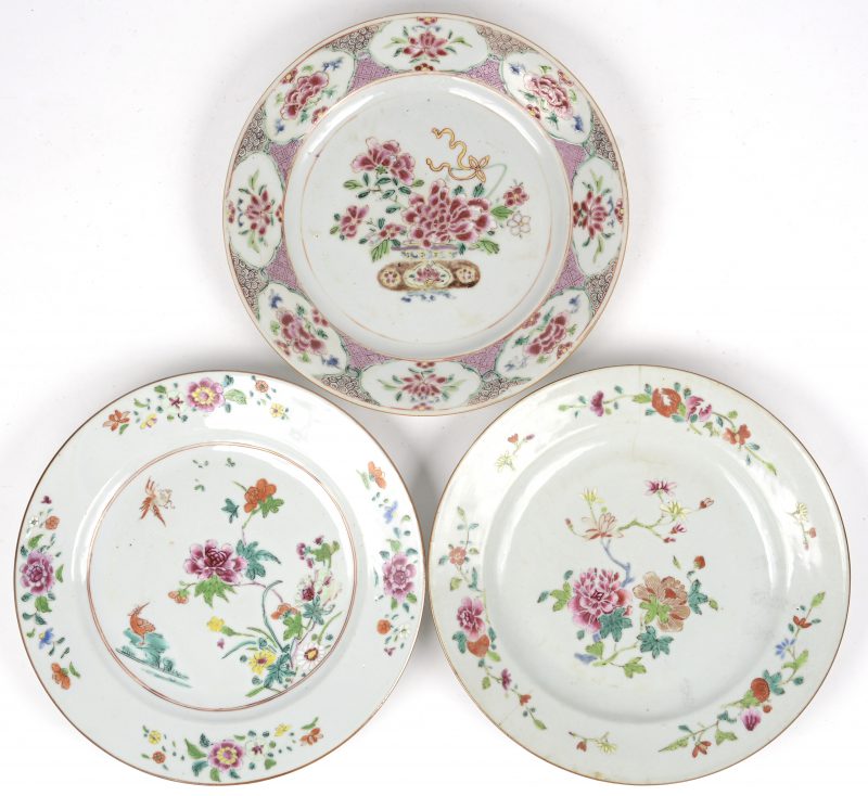 Drie diverse borden van veelkleurig Chinees porselein met famille rose decor met bloeiende planten. Tijdperk Qinglong. Eén met haarscheur.