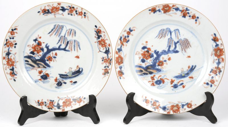 Een paar borden van Chinees porselein met een Imari decor van een visser in een landschap met treurwilg. XIXde eeuw.
