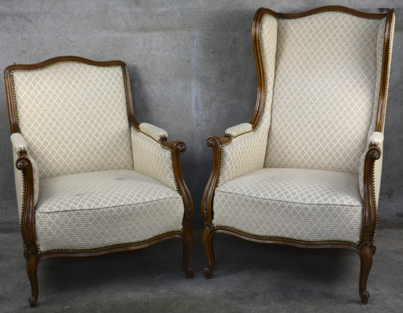 Twee verschillende notenhouten fauteuils in Régencestijl.