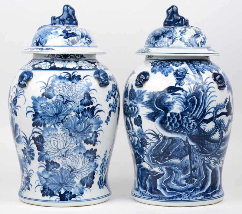 Een paar Chinees porseleinen dekselvazen met blauw op wit bloemendecor. Onderaan gemerkt.