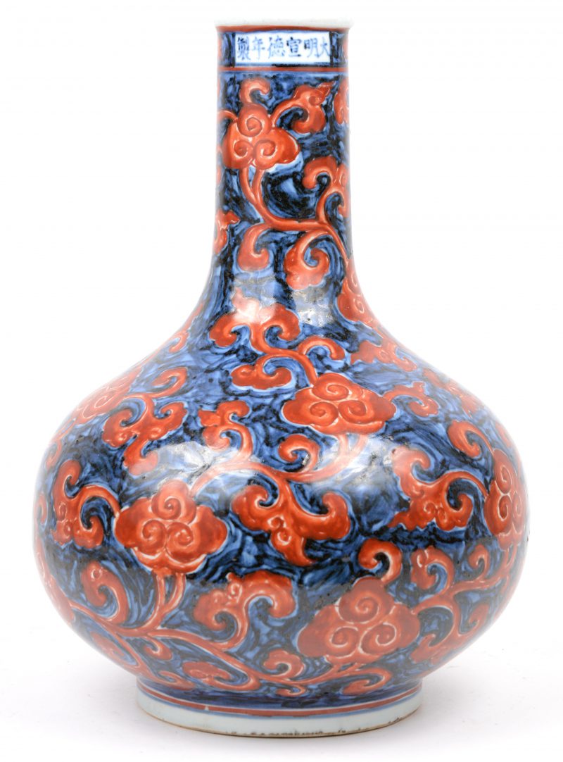 Een buikvaas van Chinees porselein met rood op blauw decor en met Ming-opschrift op de hals.