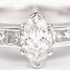 Een 18 K witgouden ring bezet met een centrale diamant markies van +- 0,50 ct. en diamant princessen met een gezamenlijk gewicht van +- 0,30 ct.