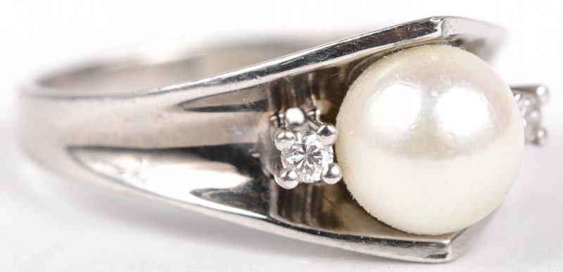 Een 18 K witgouden ring bezet met twee briljantjes en een parel.