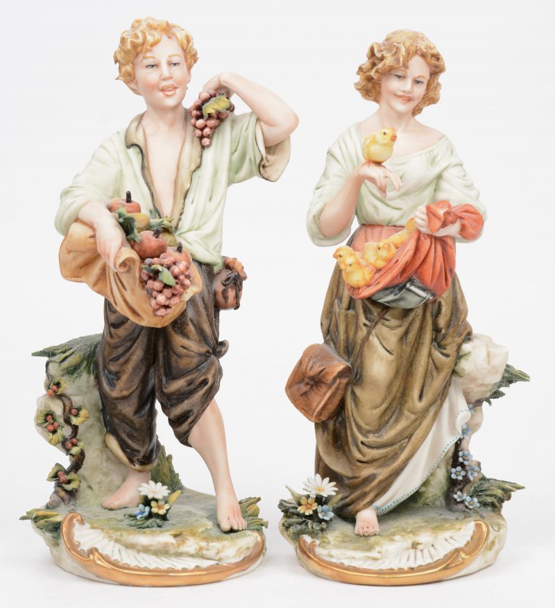 “Fruitdrager en vrouw met kuikentjes”. Een paar beeldjes in Italiaans porselein. Onderaan gemerkt.