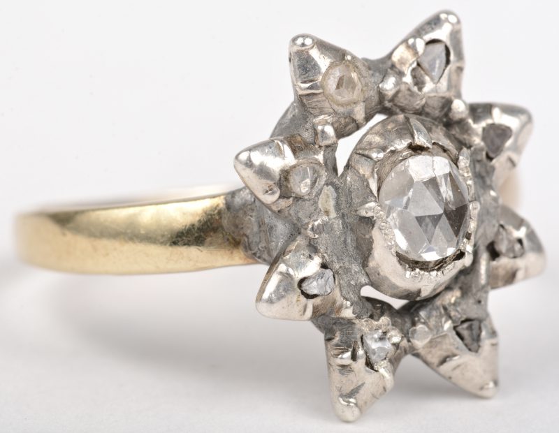 Een 18 K geelgouden ring bezet met een diamant oude slijp in zilver gezet met een gezamenlijk gewicht van +- 0,40 ct.