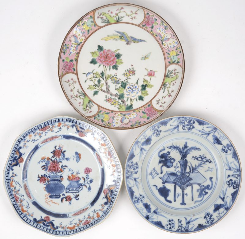Een lot van drie verschillende borden van Chinees porselein, waarbij één met blauw-wit decor van een plantenvaas, één met meerkleurig decor van bloemenvazen en het derde met meerkleurig decor van bloemen, vogels en vlinders. Respectievelijk XVIIIe, XIXe en XXe eeuw.