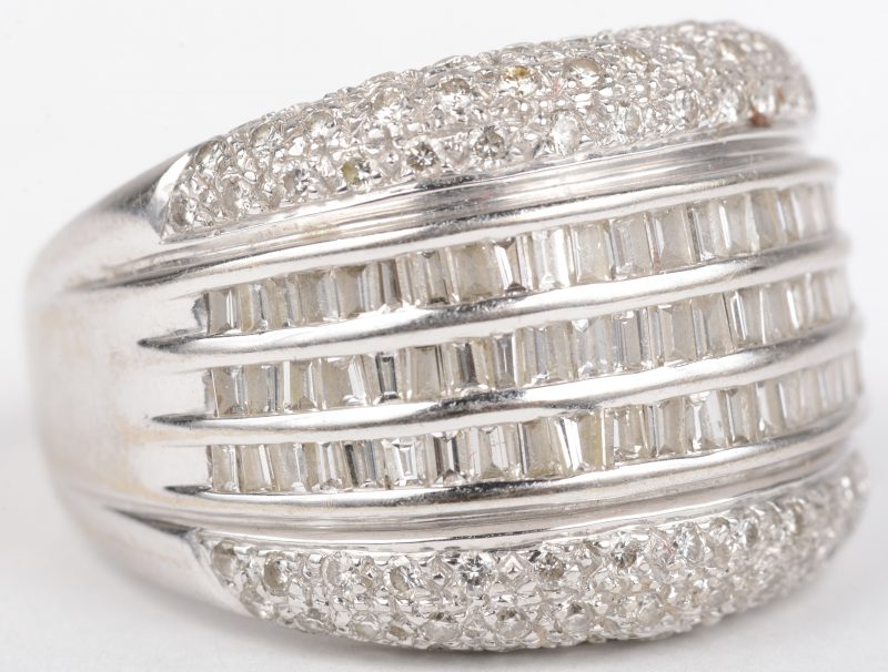 Een 18 K witgouden ring bezet met briljanten en diamant baguetten met een gezamenlijk gewicht van +- 3,50 ct. (twee kleine steentjes ontbreken).