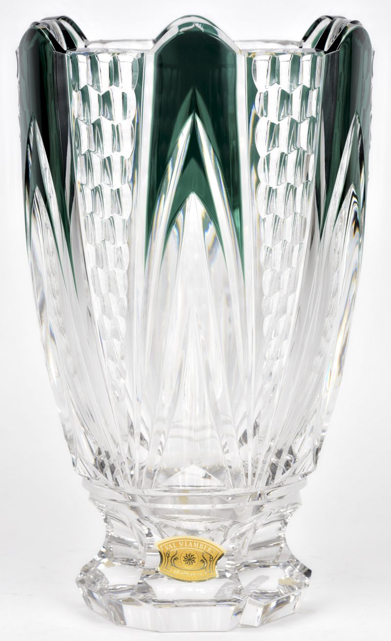 Een grote kelkvormige vaas met voetstuk van geslepen kristal, deels groen gekleurd in de massa. Onderaan gemerkt en met label.