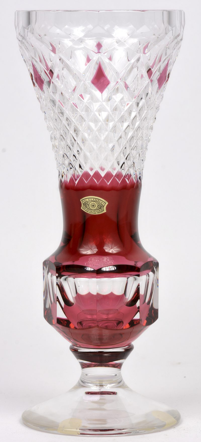 Een kelkvormige vaas van geslepen kristal, in de massa deels rood gekleurd. Onderaan gemerkt en genummerd. Met label.