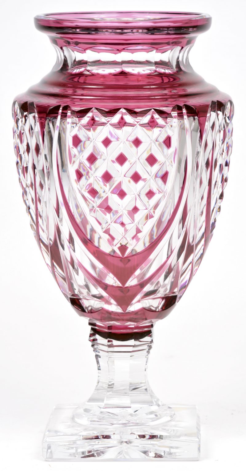Een vaas op voetstuk van geslepen kristal, in de massa deels wijnrood gekleurd. Onderaan gemerkt en genummerd.