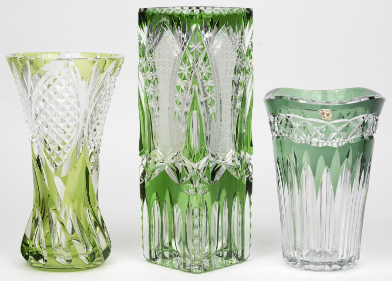 Drie kleine vazen van geslepen kristal. Deels in de massa groen gekleurd. Onderaan gemerkt, behalve de vierkante.