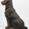 Een zittend hondje van gepatineerd brons.