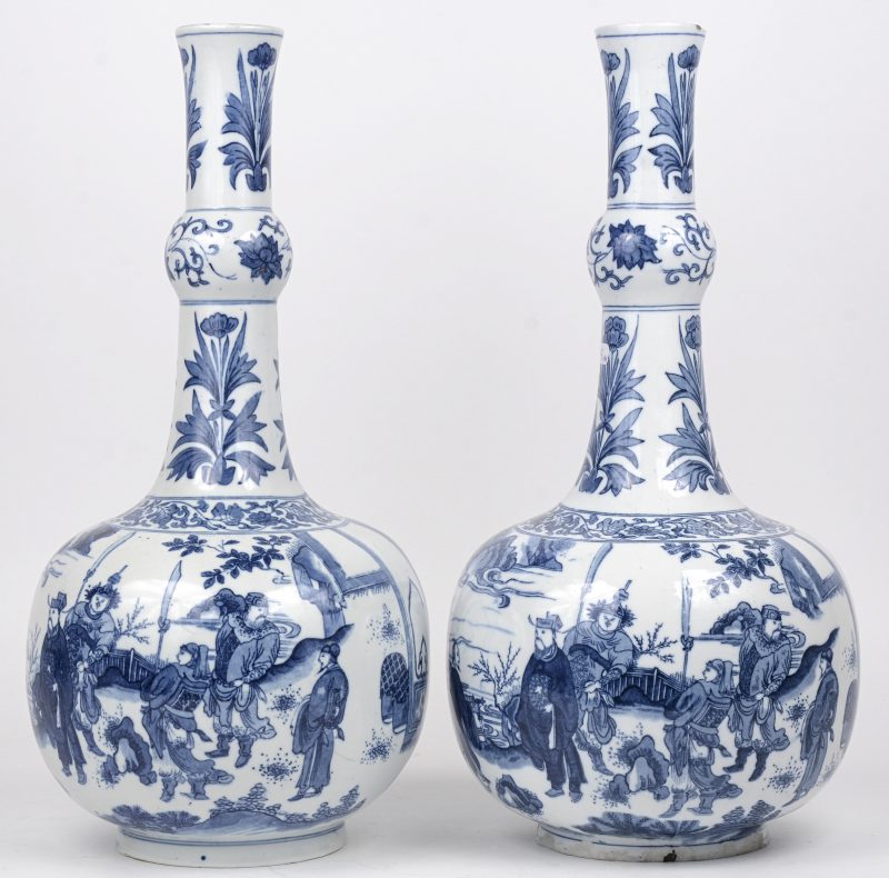 Een paar knobbelvazen van Chinees porselein met blauw op wit gedrukt decor van personages in een landschap. Randschade boven- en onderaan.