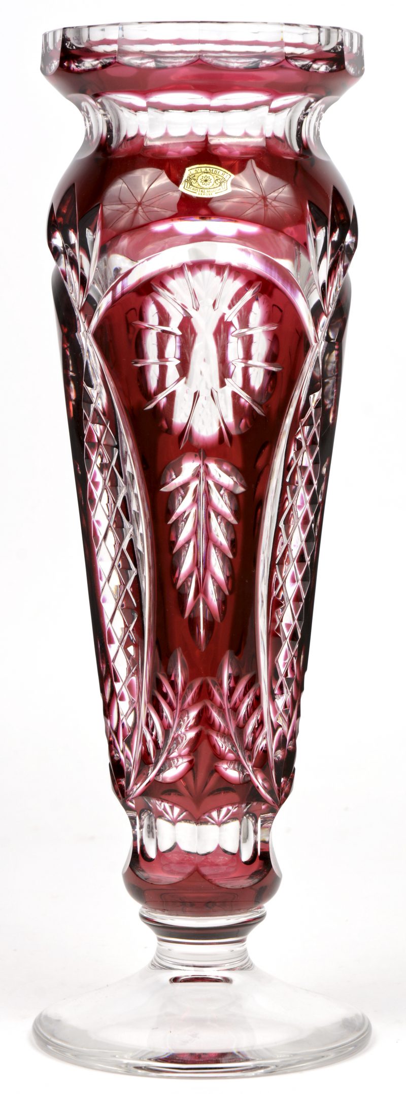 Een hoge vaas met ronde voet van geslepen kristal, in de massa deels rood gekleurd. Onderaan gemerkt, gesigneerd H. Lega. En met label.