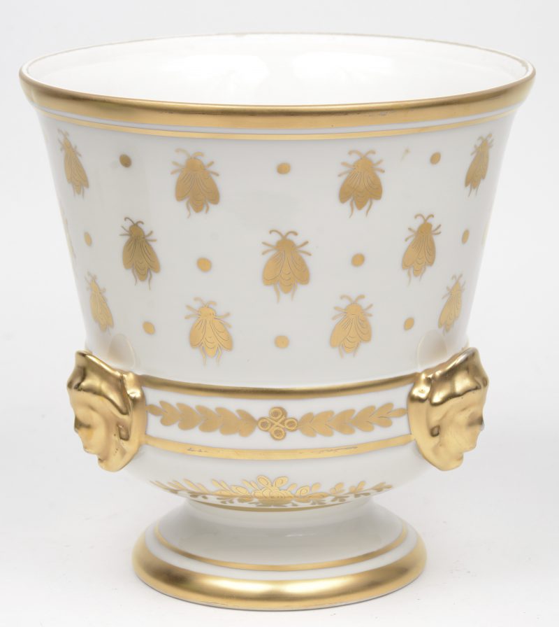Een sierjardinière van Parijs’ porselein met verguld decor van bijen en gekruiste fakkels en met kopjes in reliëf. Onderaan gemerkt.
