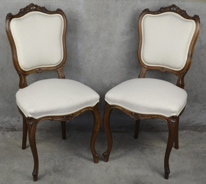 Een paar stoelen van gebeeldhouwd notenhout in Lodewijk XV-stijl.